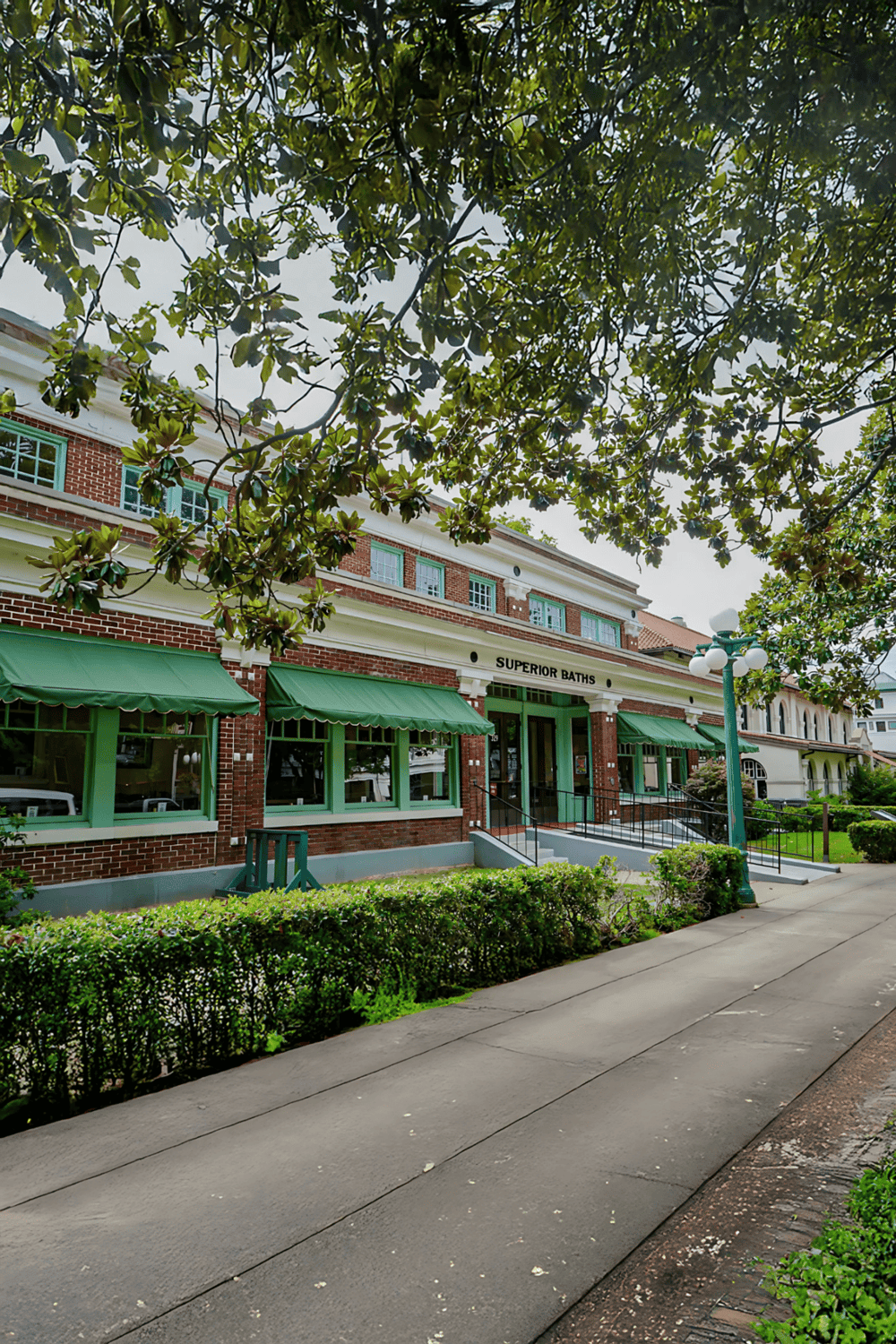 Quiet neighborhood with historic buildings and greenery in front of Superior Baths.