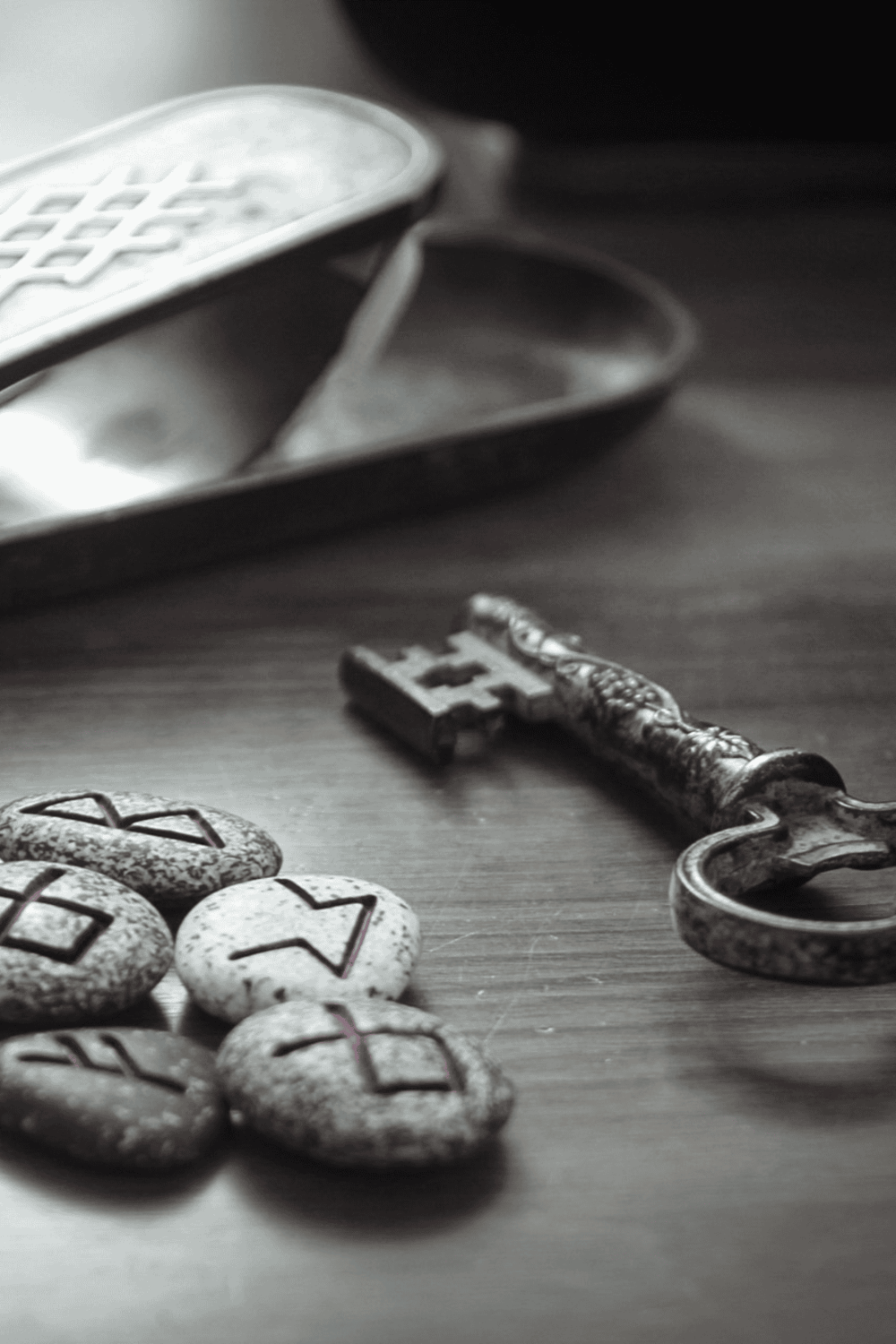 1. Vintage metal key and carved stone game pieces on wooden surface.