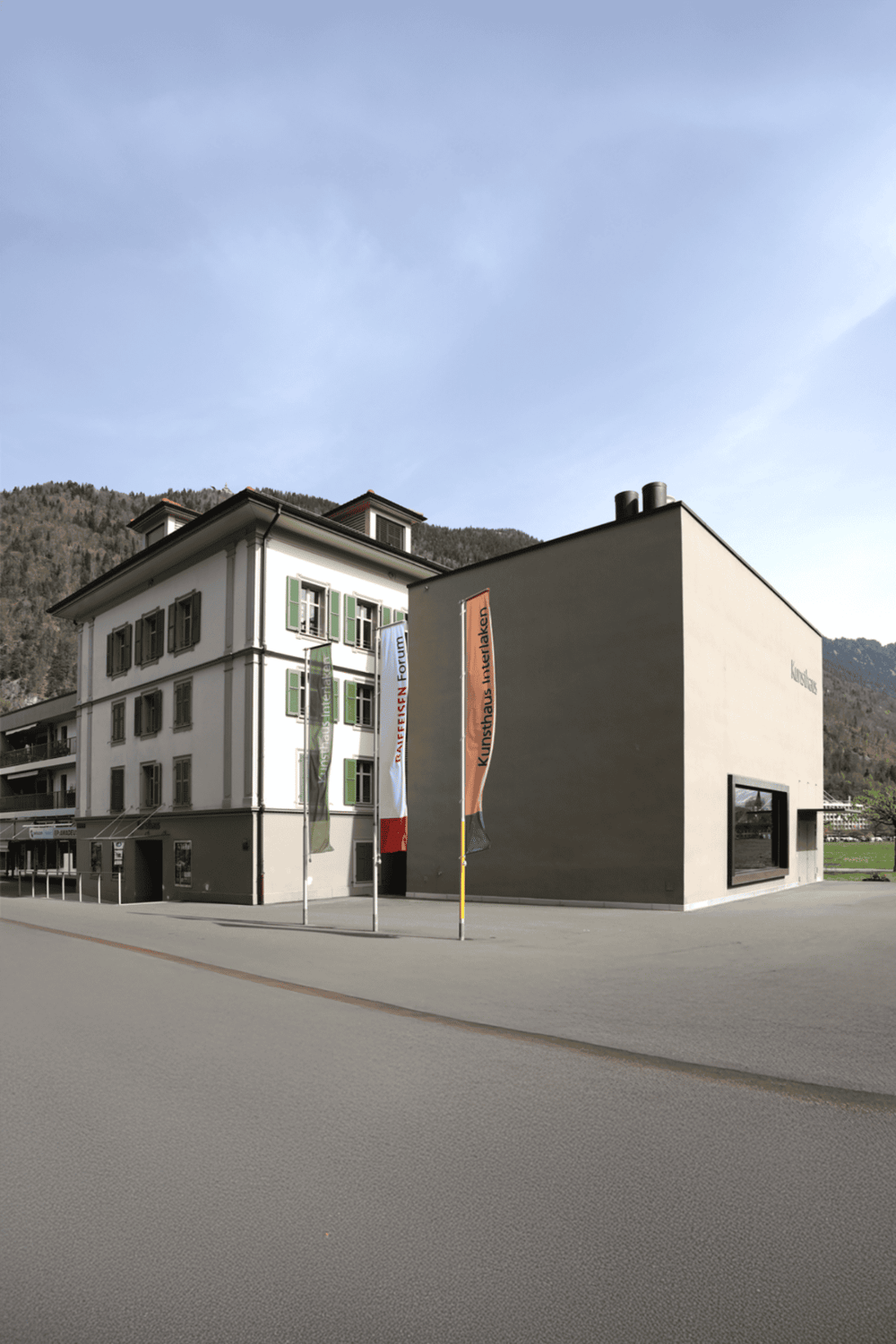 Contemporary art gallery facade in a mountain town, showcasing QuestForDirections branding.