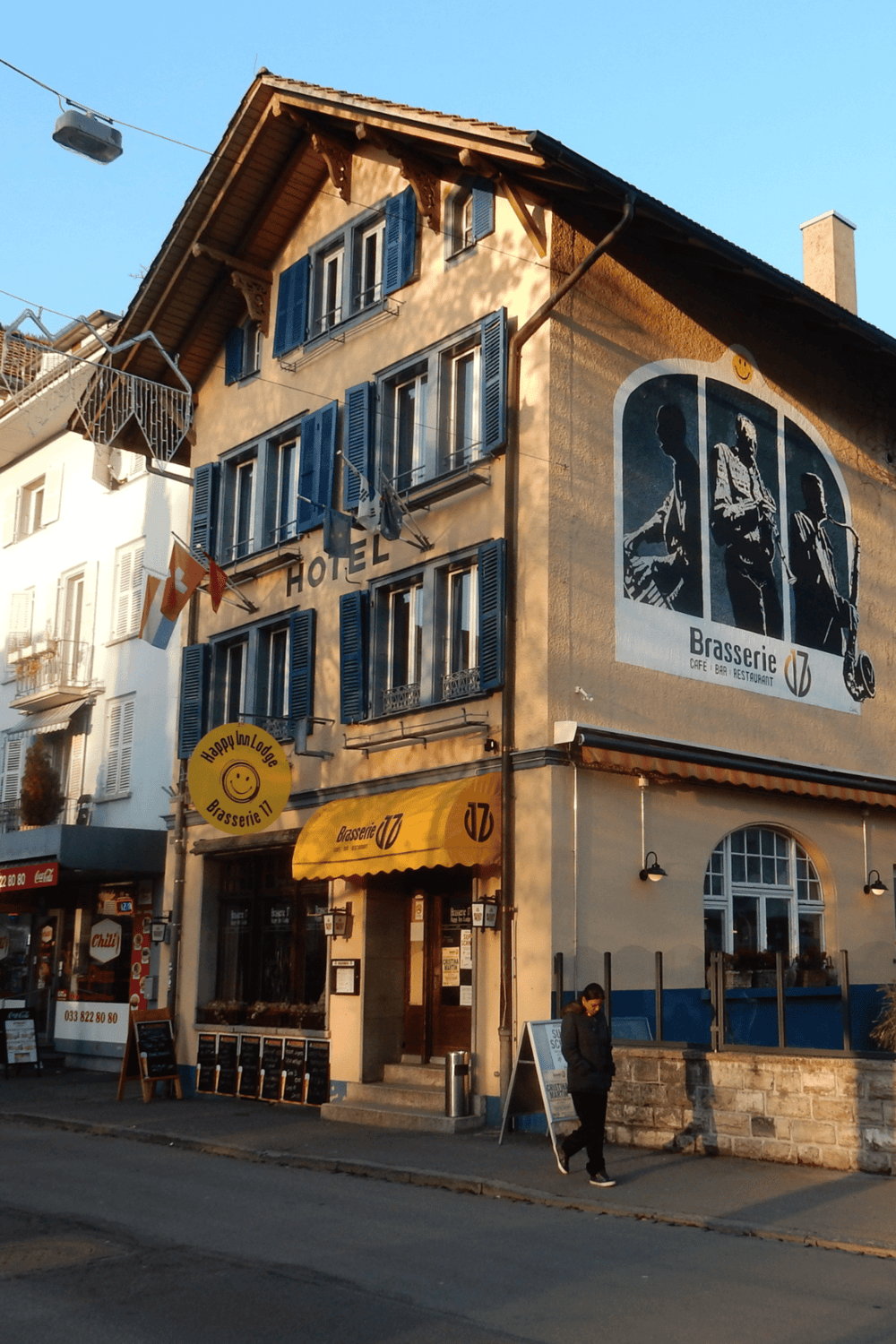 Charming Swiss hotel and brasserie with vibrant mural, perfect for culinary and lodging experiences.