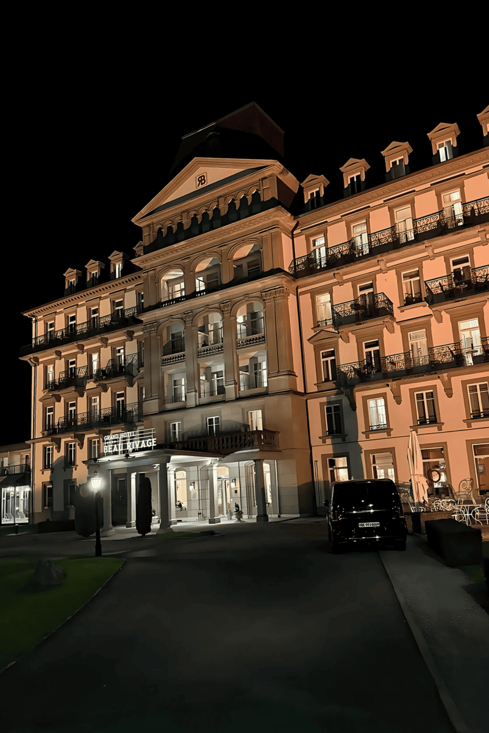 Elegant night view of Grand Hotel Beaulieu Vue, illuminated with warm lighting, showcasing luxury hospitality.