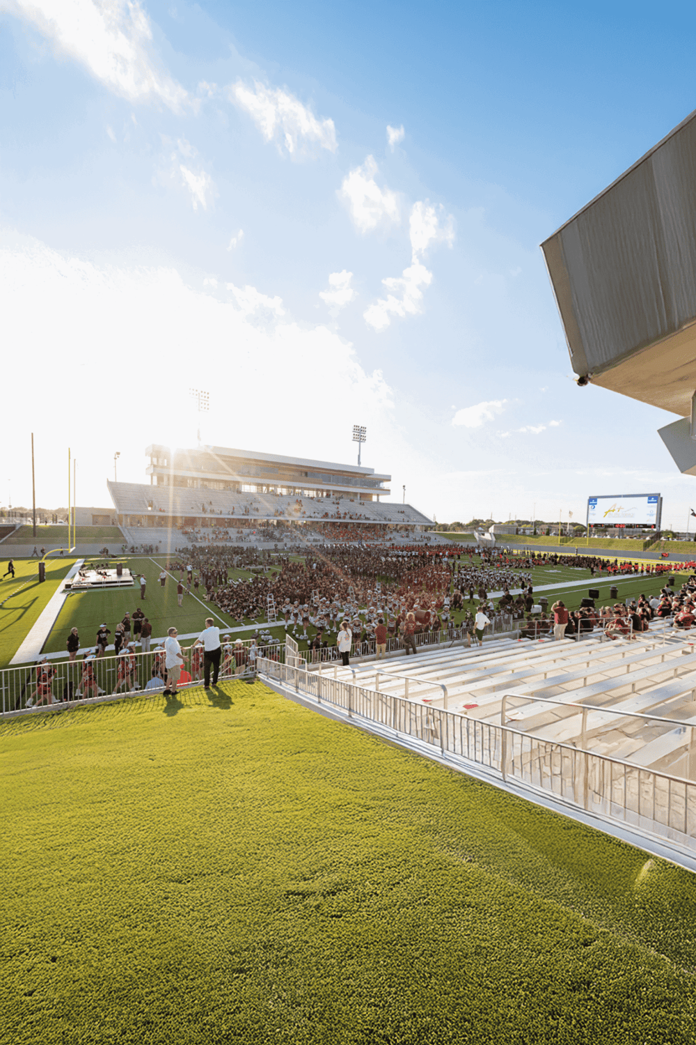 Greatest football stadium during sunset with fans, field, and bleachers.