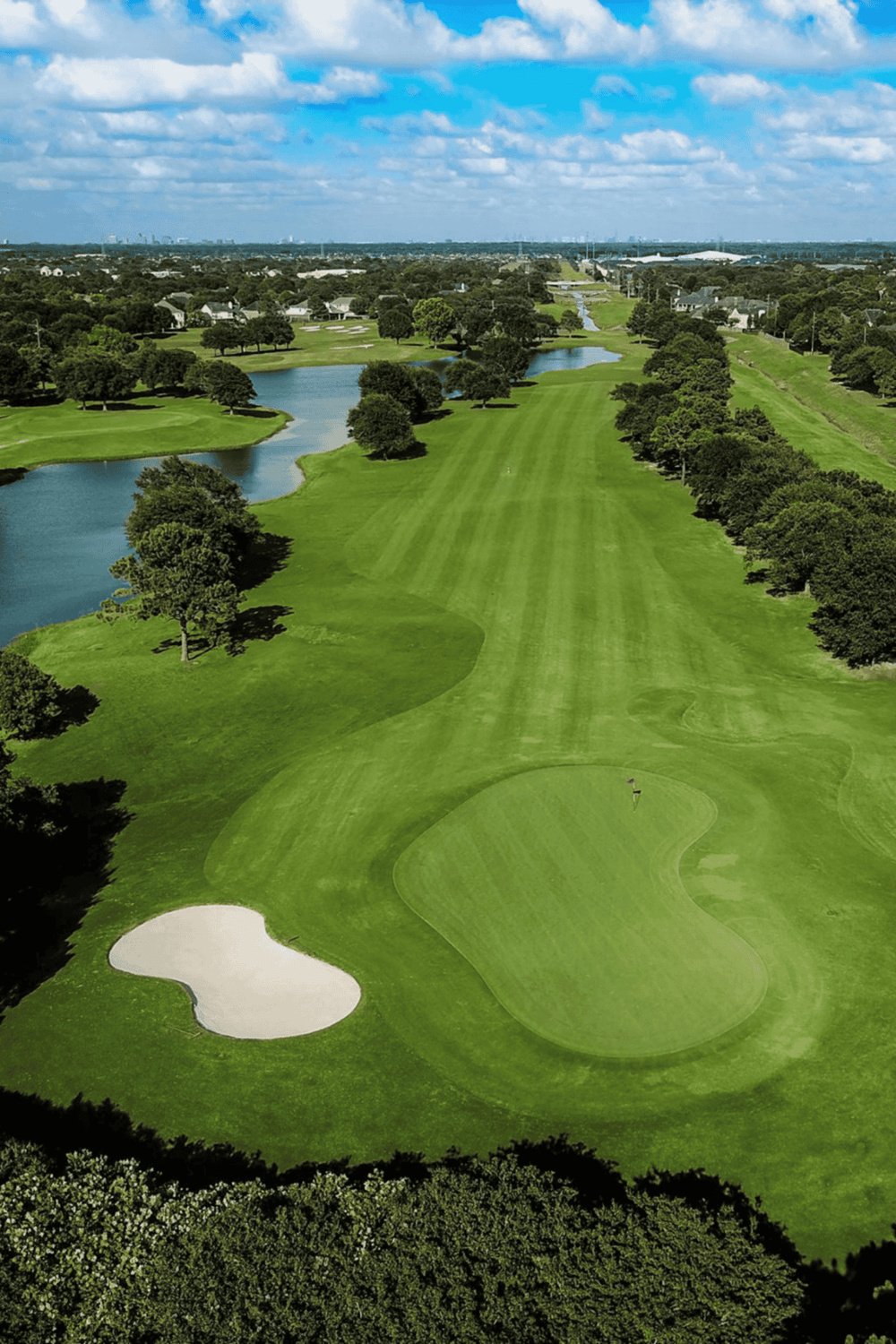 Lush golf course with water hazards and sand bunkers in a scenic outdoor setting.