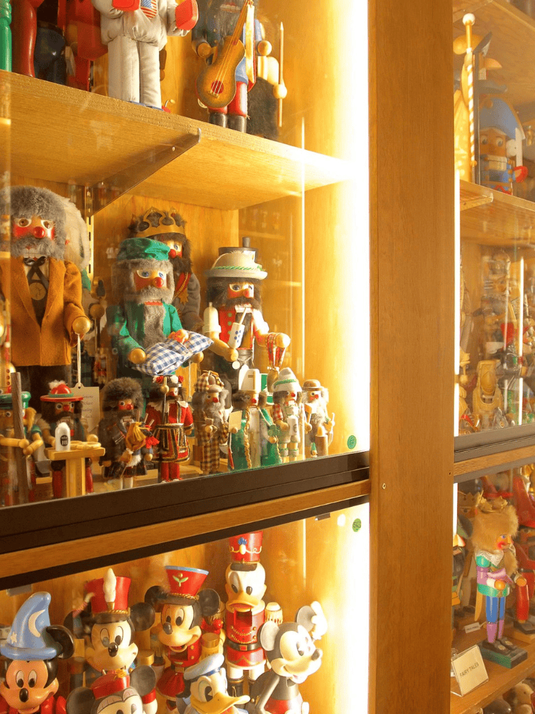 Vintage holiday nutcracker and Disney Mickey Mouse collectibles display cabinet.