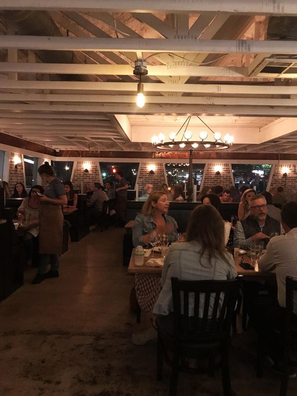 Cozy restaurant dining area with warm lighting, exposed brick walls, and modern decor for a memorable dining experience.