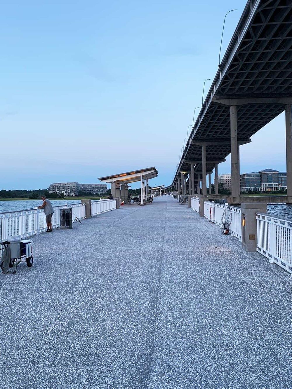Panoramic view of a riverside pier under a bridge, perfect for fishing and leisure activities.