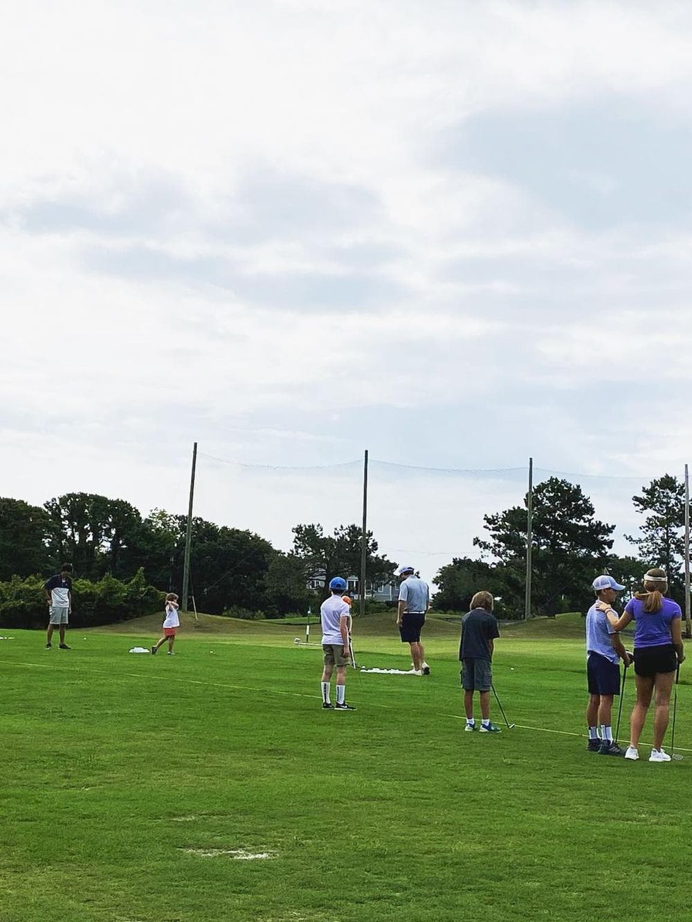 People playing mini golf on a lush green course, enjoying family-friendly outdoor activities and entertainment.
