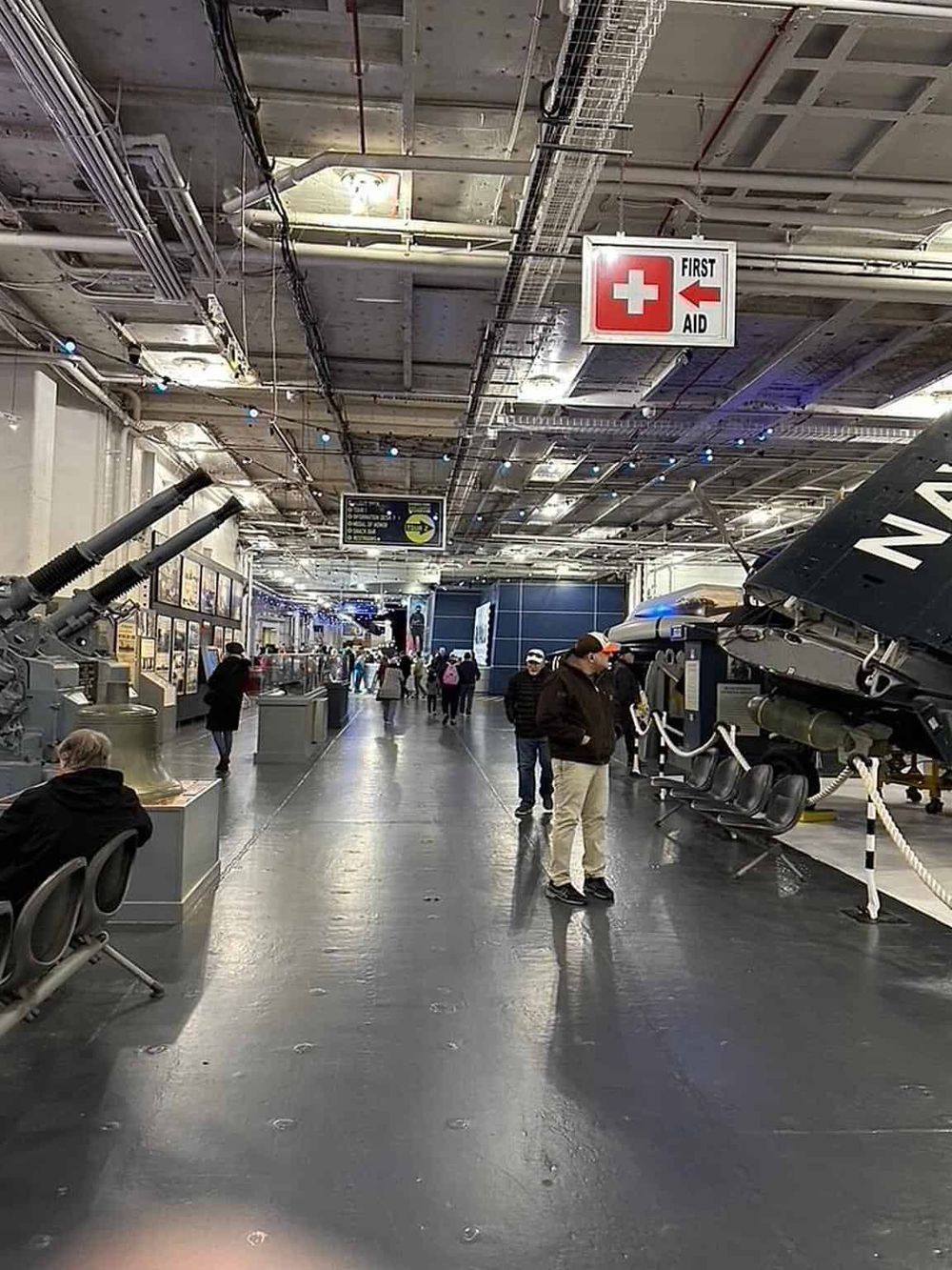 Modern museum exhibit featuring military tanks and artifacts with visitors exploring.