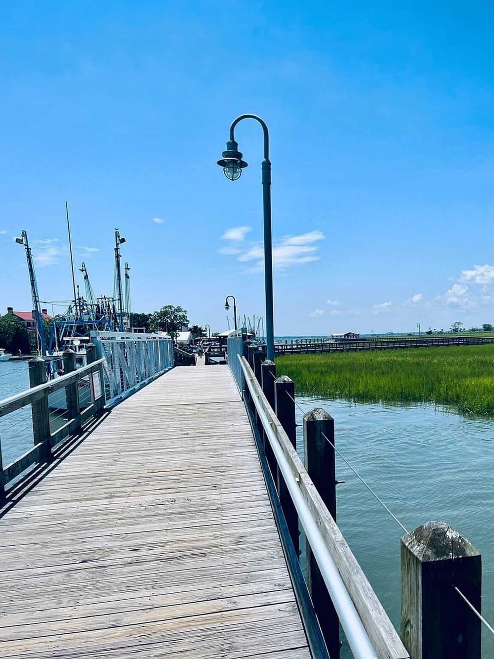 Serene dock at Cottage City Cove with boats and scenic view, ideal for waterfront activities and relaxing by the water.
