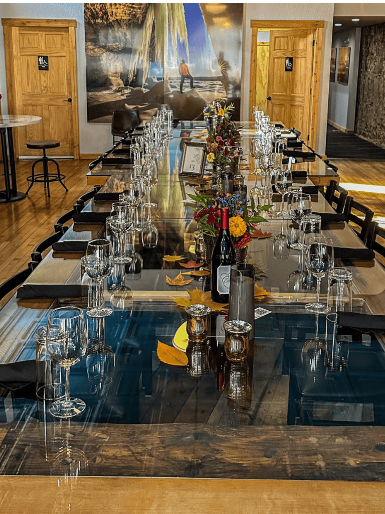 Elegant private dining setup with wine bottles, floral centerpieces, and glassware for special occasions.