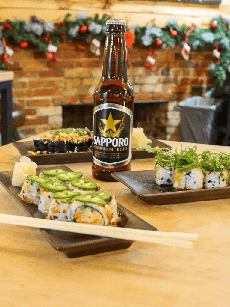 Cold Japanese sushi rolls served with beer on a restaurant table during holiday celebration.