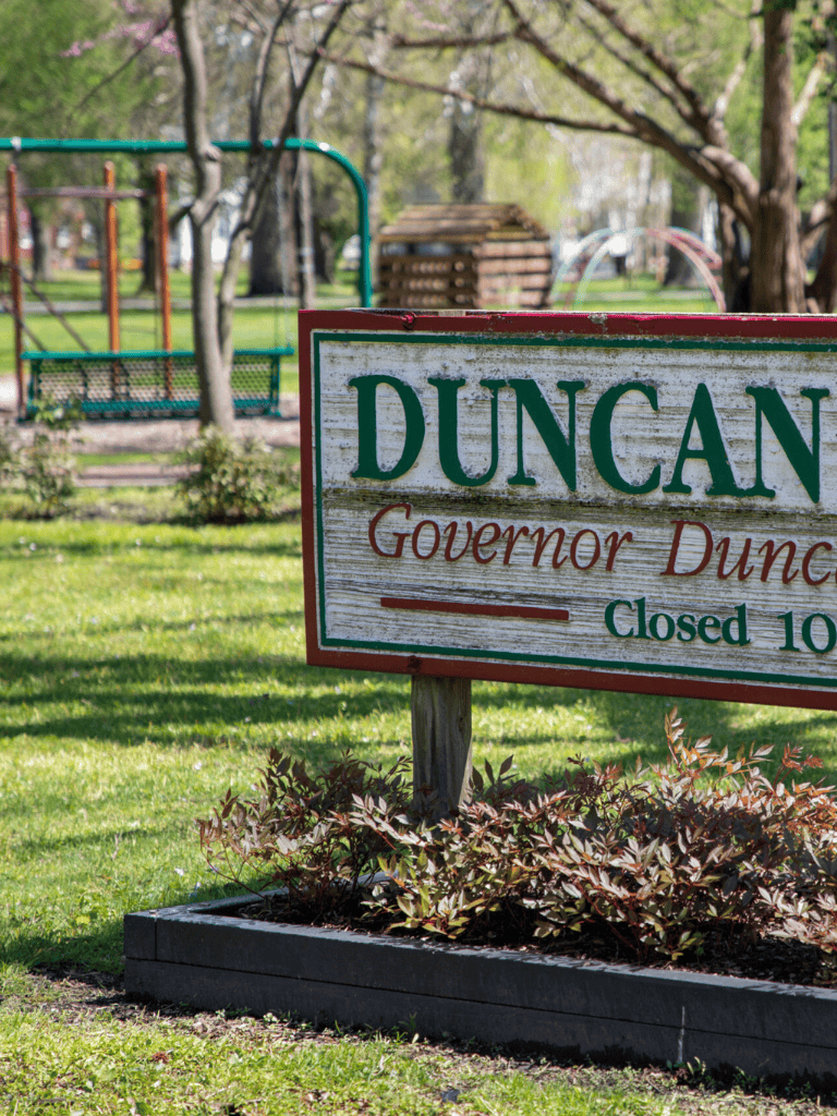 Duncan city park sign, playground and lush greenery, peaceful outdoor recreation area.