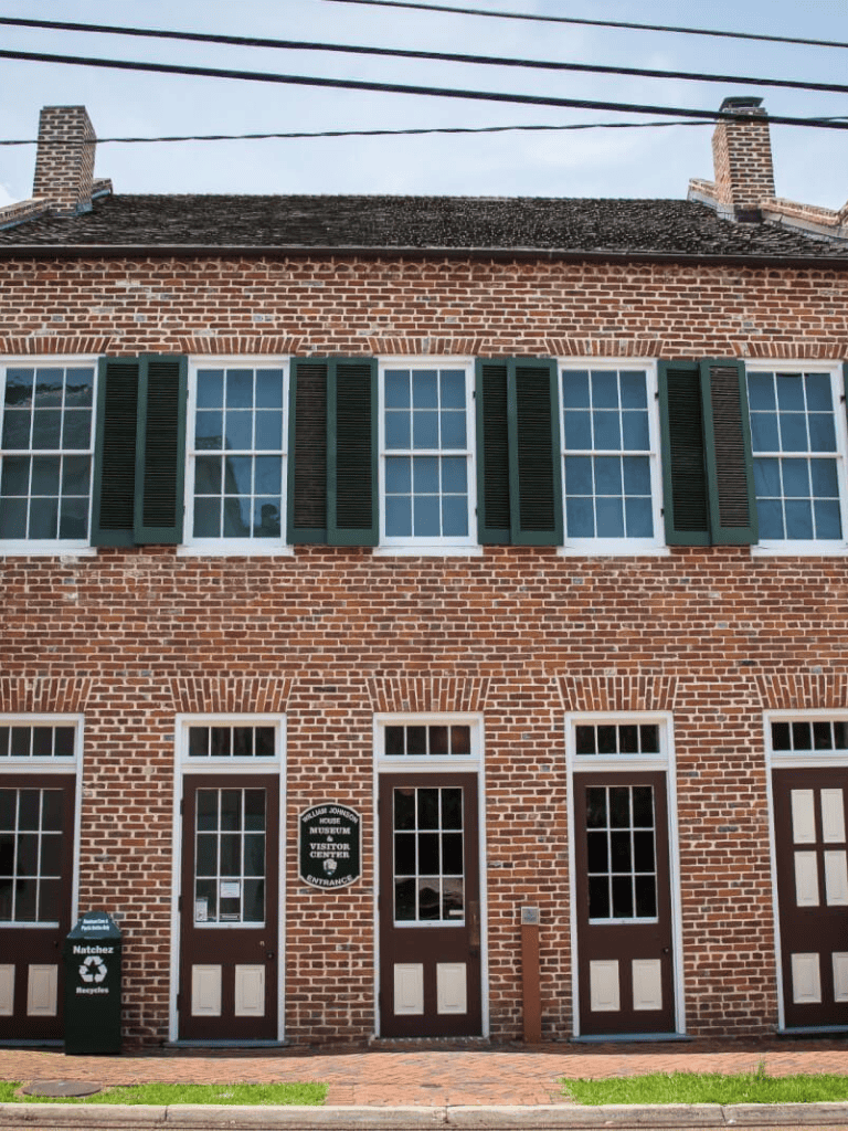 Colorful brick building with historic architecture and visitor center signage in a quaint town setting.