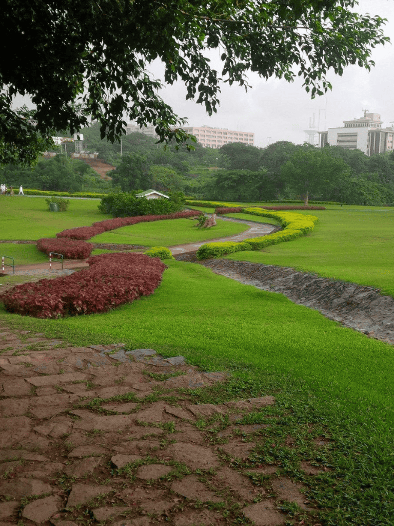 Serene park with lush greenery and winding pathways for relaxation and outdoor activities.