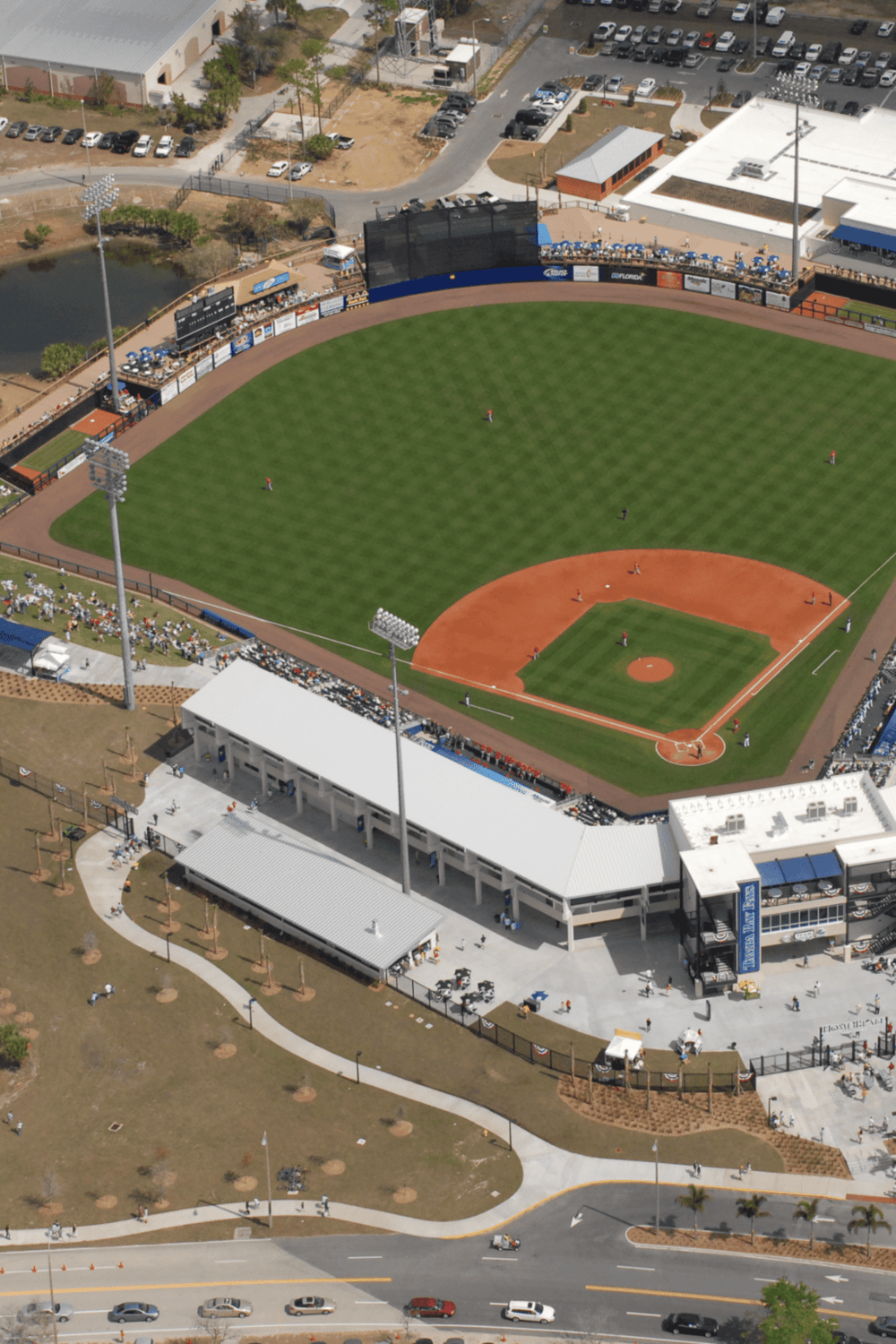 Aerial view of a baseball stadium with surrounding parking and recreational facilities.