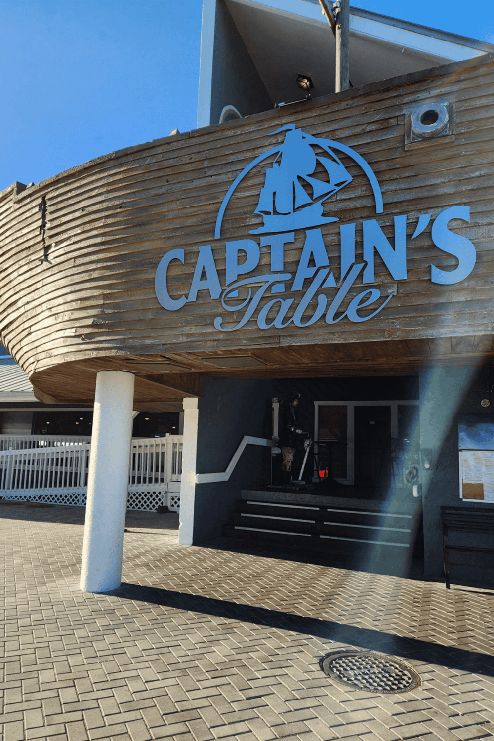 Seaside restaurant with a nautical theme, titled Captain's Table, offering seafood and oceanfront dining experience.