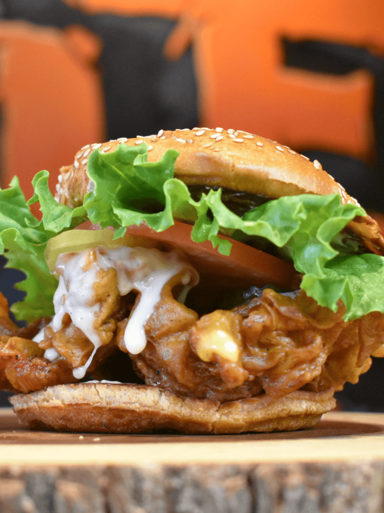 Savory fried chicken sandwich with lettuce and tomato on sesame bun, popular fast food meal.