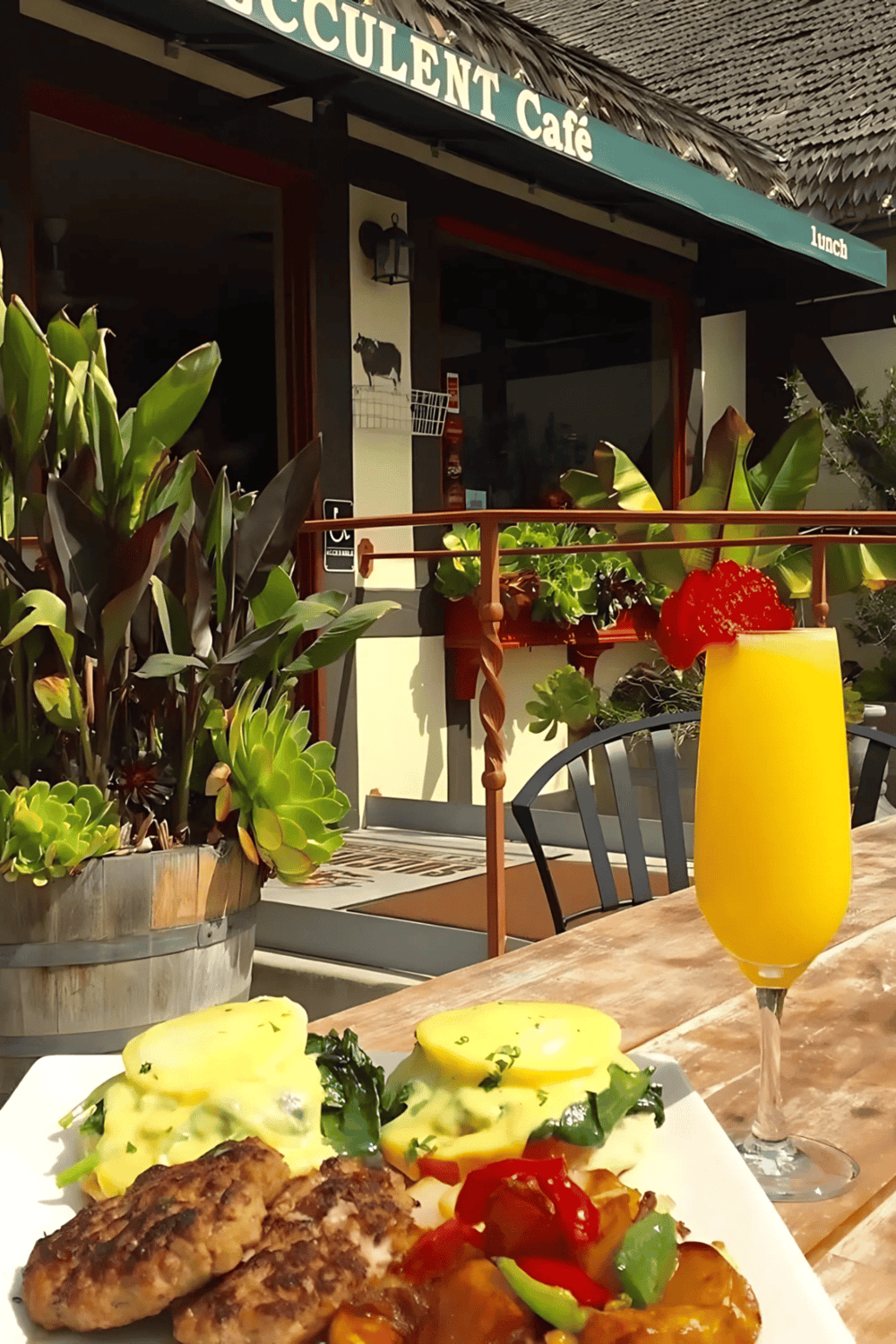 Fresh breakfast at a tropical cafe with eggs, sausages, and a mango smoothie.