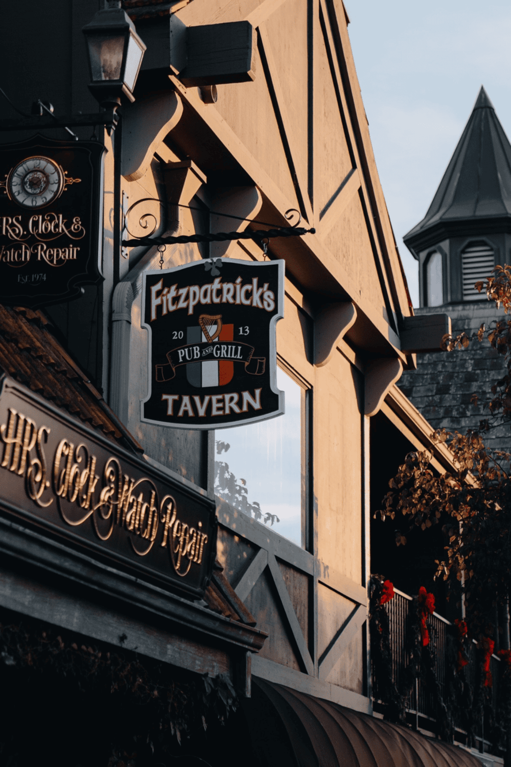 Charming Irish pub exterior with tavern sign, autumn decor, and traditional architecture.