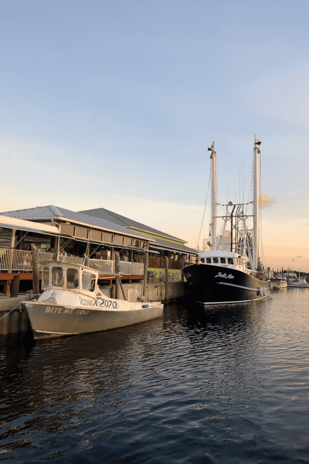 Quaint marina with boats docked at sunset, highlighting coastal travel and boating excursions.
