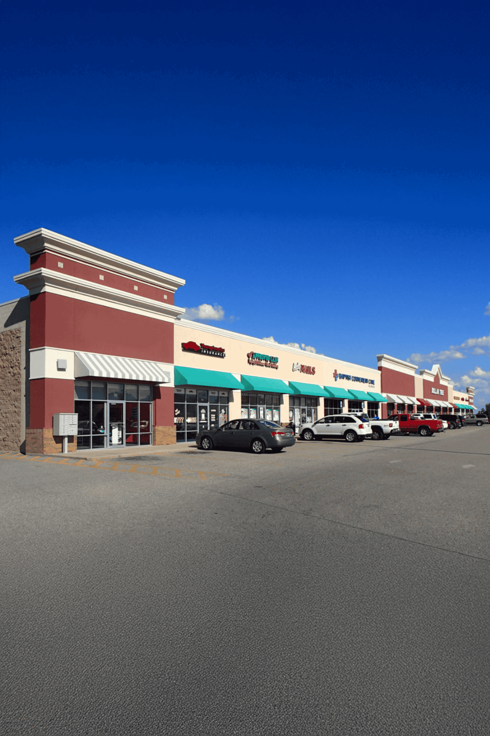Convenience store and retail shops inside a shopping center exterior.