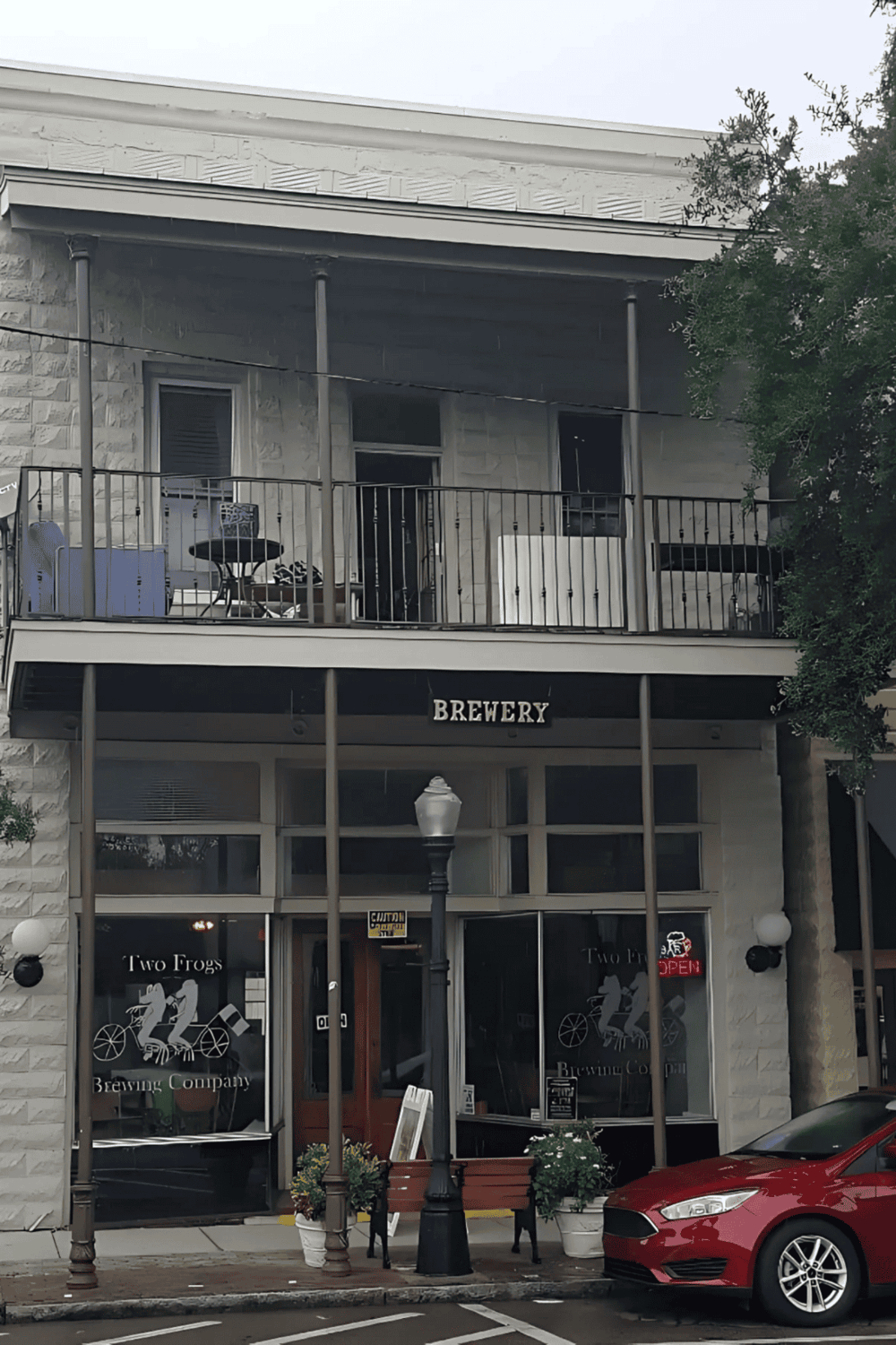 1. Charm city brewery with storefront, outdoor seating, and upper balcony in downtown.
