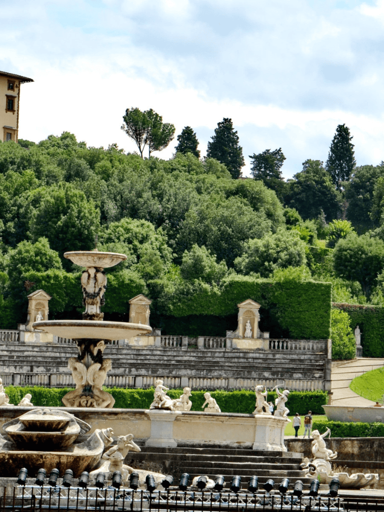 Renaissance-style Italian fountain with ornate sculptures and lush greenery in Florence, Italy.