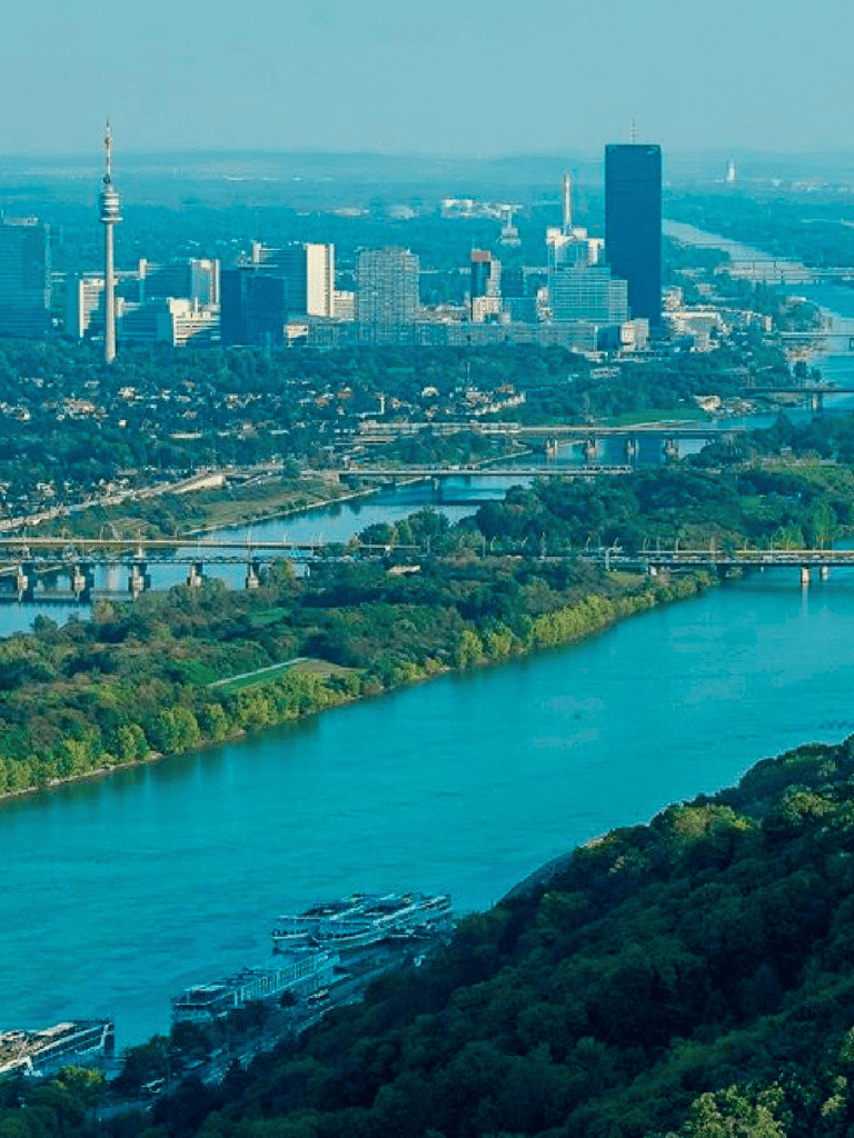 Aerial view of a cityscape with skyscrapers, river, and green parks inQuestForDirections, focusing on urban navigation and city tours.