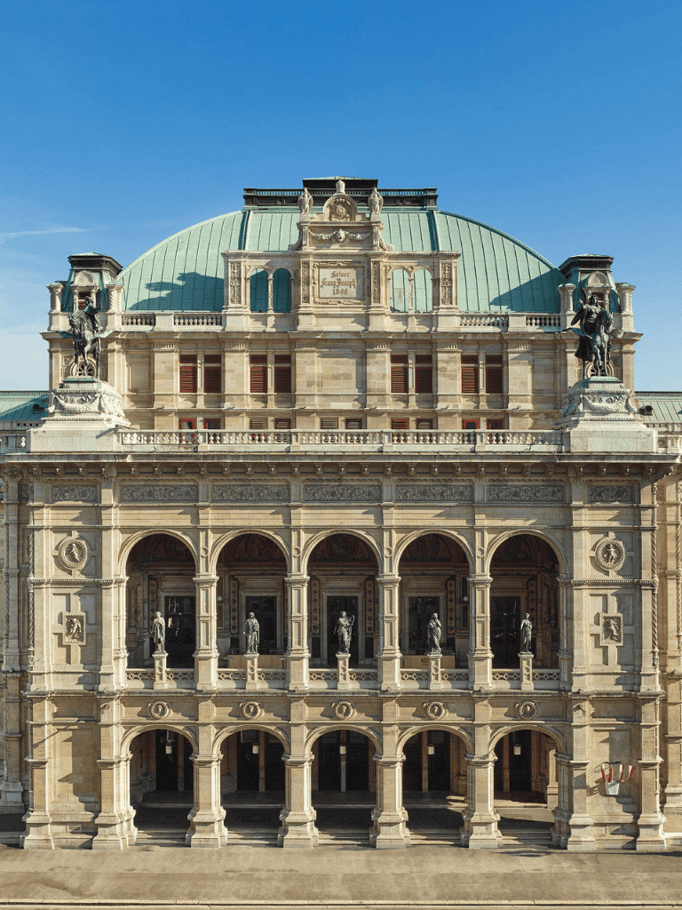 Elegant historic building with arched windows and statues, showcasing classic architecture and intricate details.