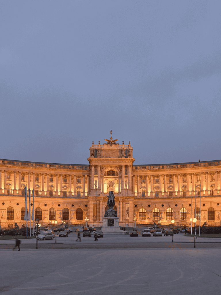 Grand historic building illuminated at dusk in Vienna.