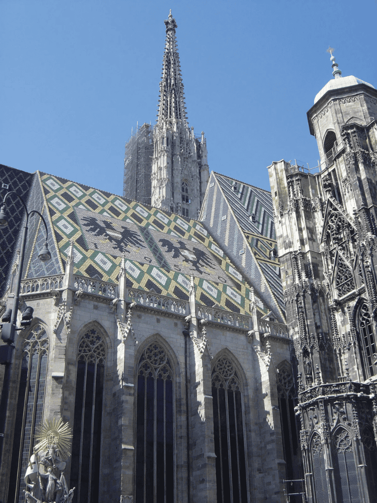 Majestic Gothic cathedral with ornate architecture and colorful tiled roof.
