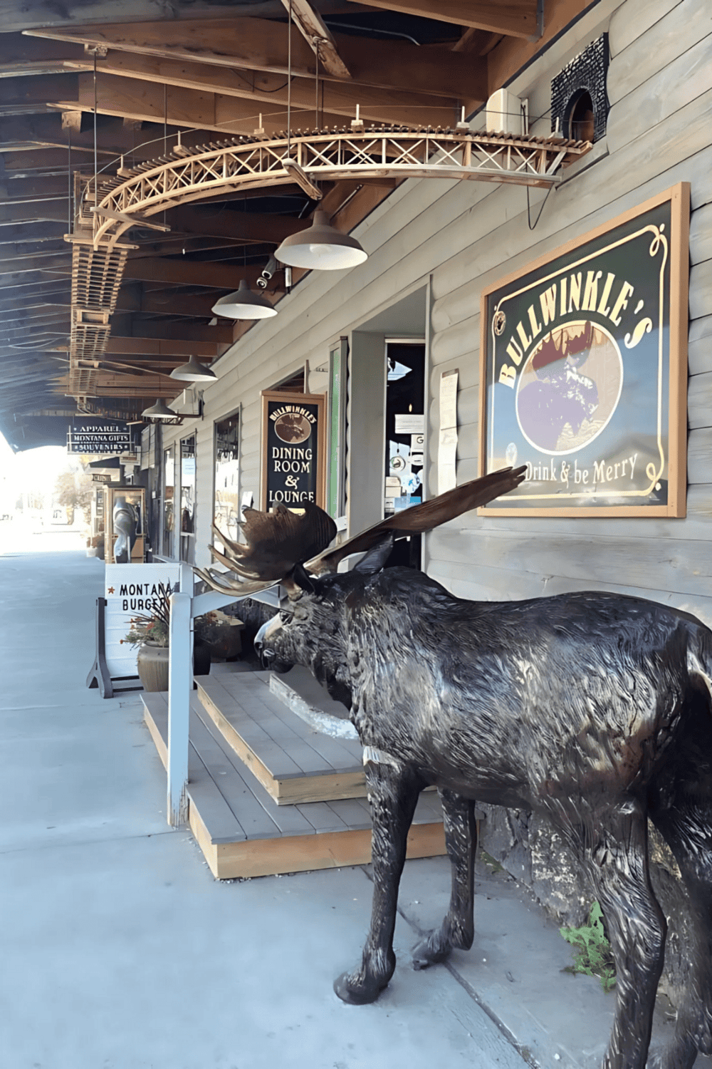 Colorful elk statue outside Bullwinkle's restaurant and lounge in Montana, with rustic wooden decor and mountain-themed signage.