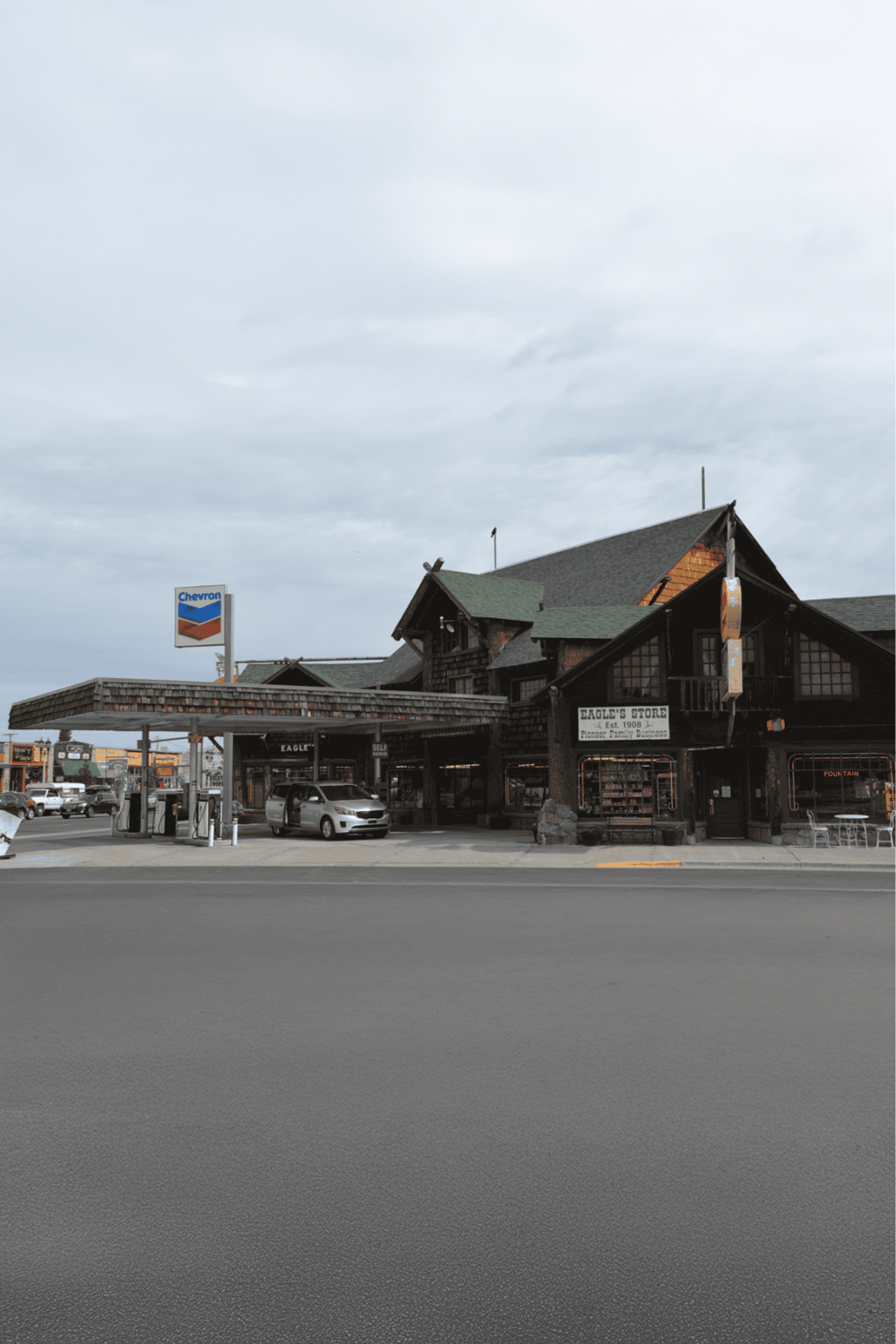 Agnostic gas station and general store in a rustic mountain town, offering fuel and local shopping.