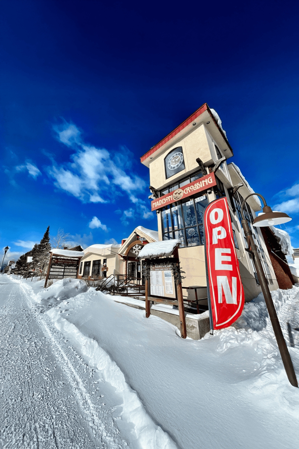 Bright snowy scene at Madison Crossing Lodge, a popular local restaurant and shop in winter.