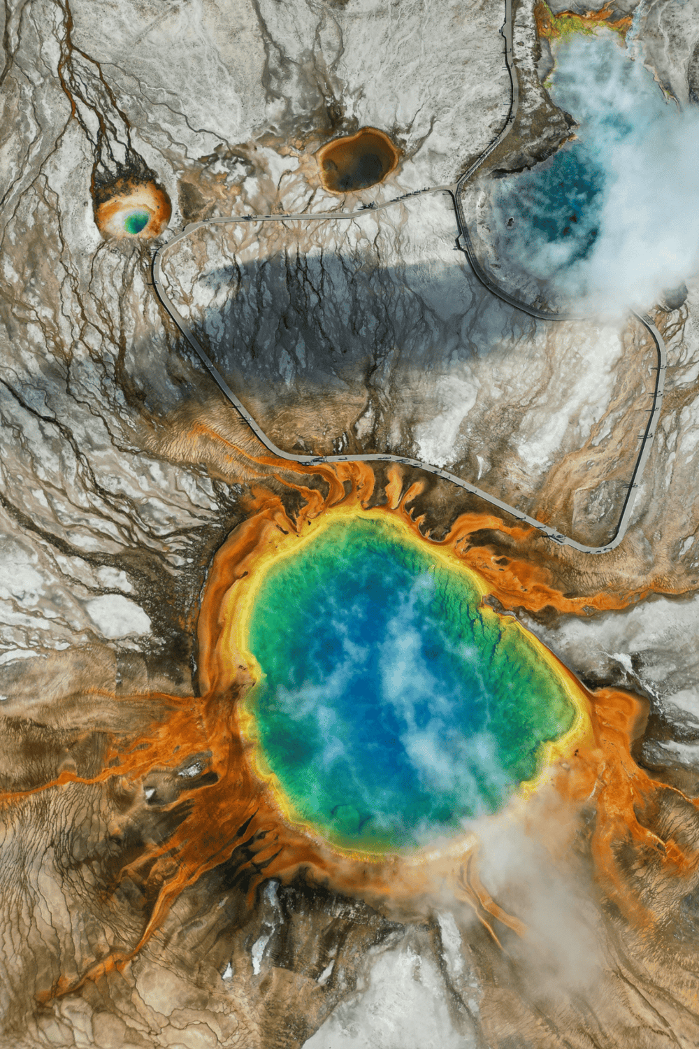 Colorful geothermal hot springs with steaming water and mineral deposits at Yellowstone National Park.