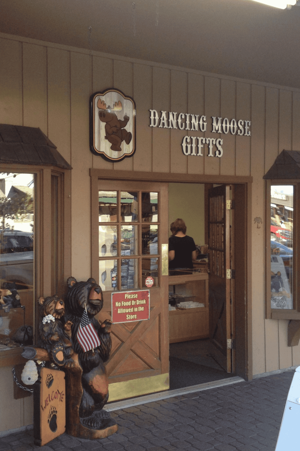 Whimsical gift shop entrance with Dancing Moose Gifts sign, wooden decor, and moose statues, perfect for unique souvenir shopping.