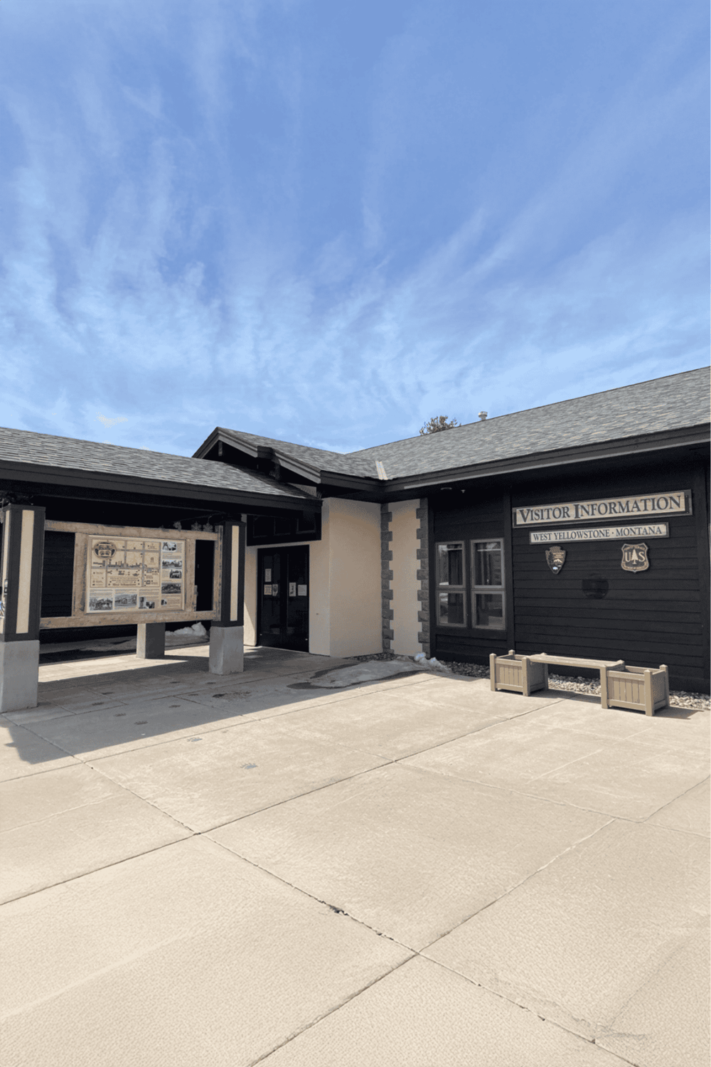 Historic visitor information center at Yellowstone National Park, Montana, featuring a U.S. Forest Service emblem.
