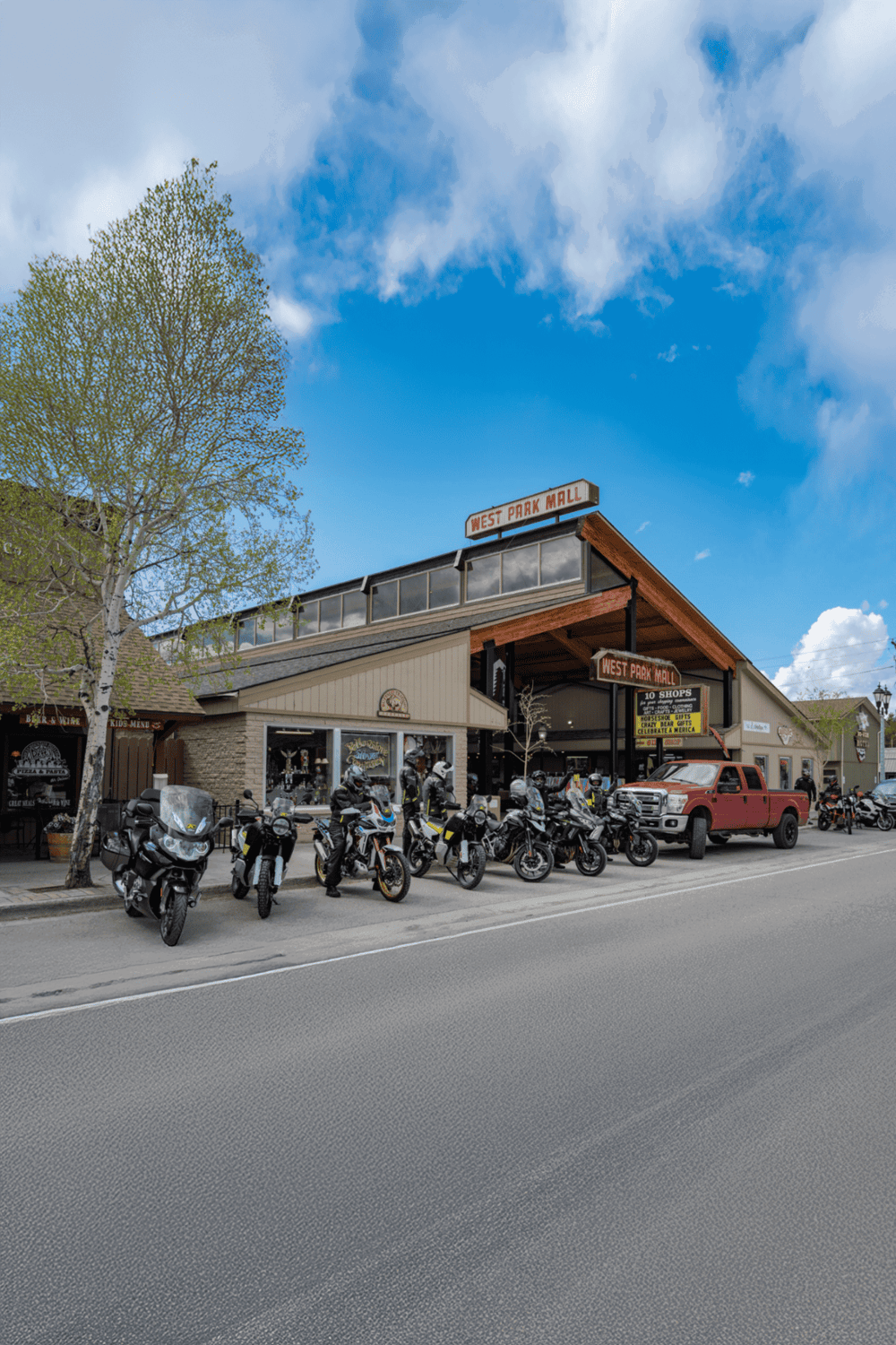 Motorcycle parking outside West Park Mall in a small town on a sunny day.