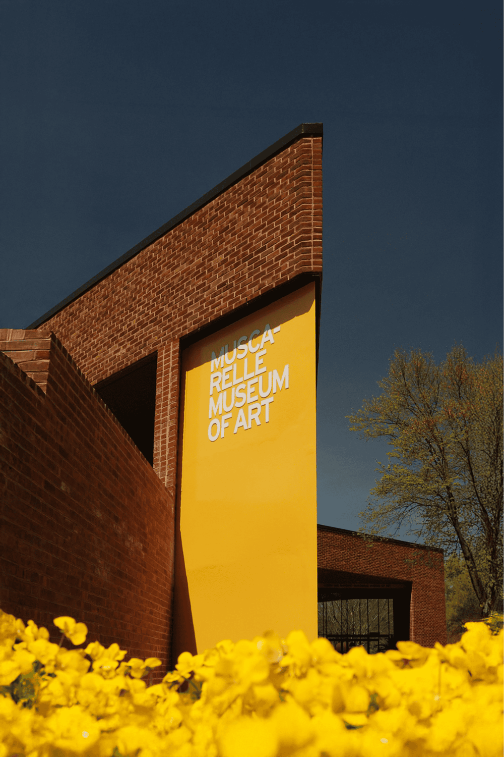 MUSCA-RELLÉ MUSEUM OF ART, modern architecture and vibrant yellow signage at the museum entrance.