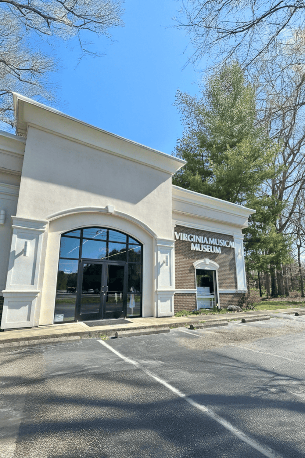 Historic Virginia Musical Museum building with a modern storefront, sunny day in spring.