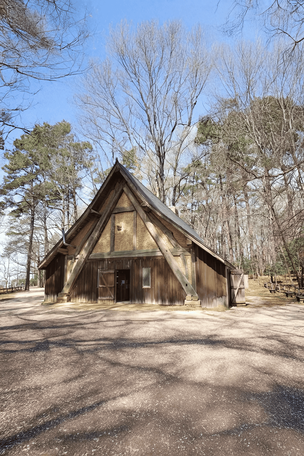 Rustic A-frame cabin in wooded park during daytime, perfect for outdoor adventures and nature escapes.