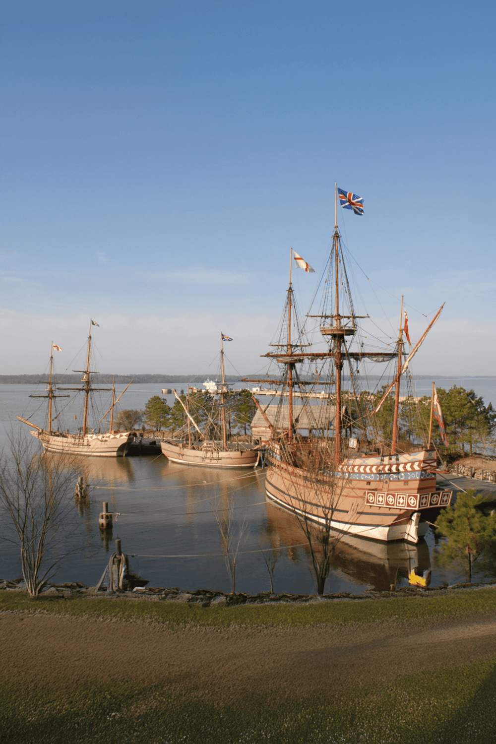 Historical sailing ships docked at a waterfront port, representing maritime adventure and nautical heritage.