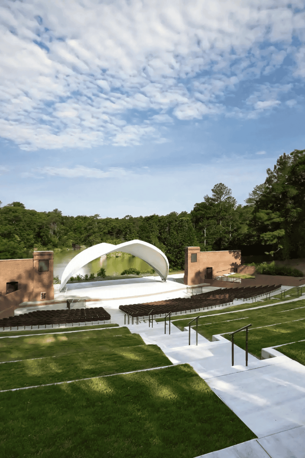 Open-air amphitheater with stage and seating in scenic outdoor setting for events and performances.