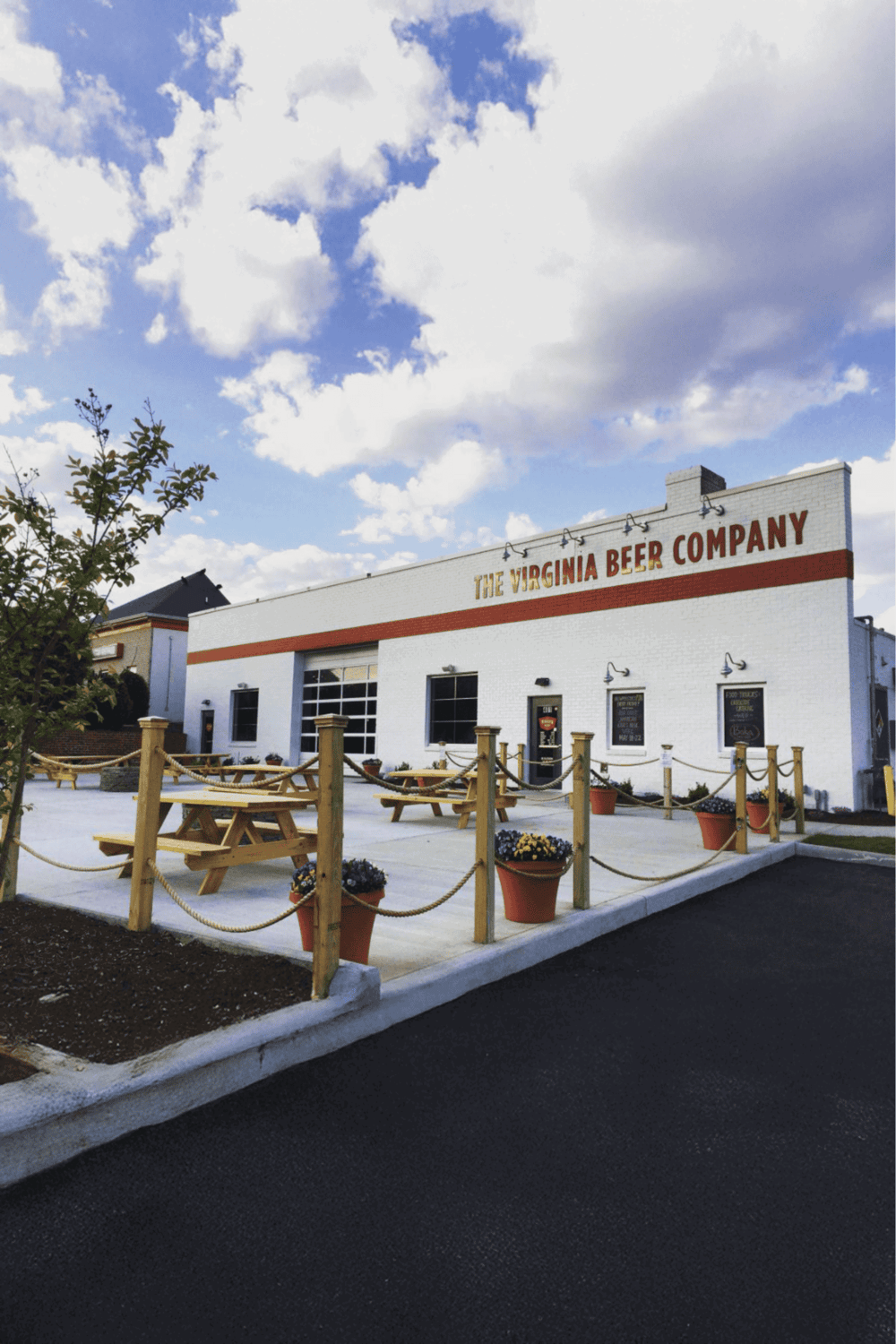 Craft beer brewery exterior at Virginia Beer Company, outdoor seating, clear sky, welcoming atmosphere.