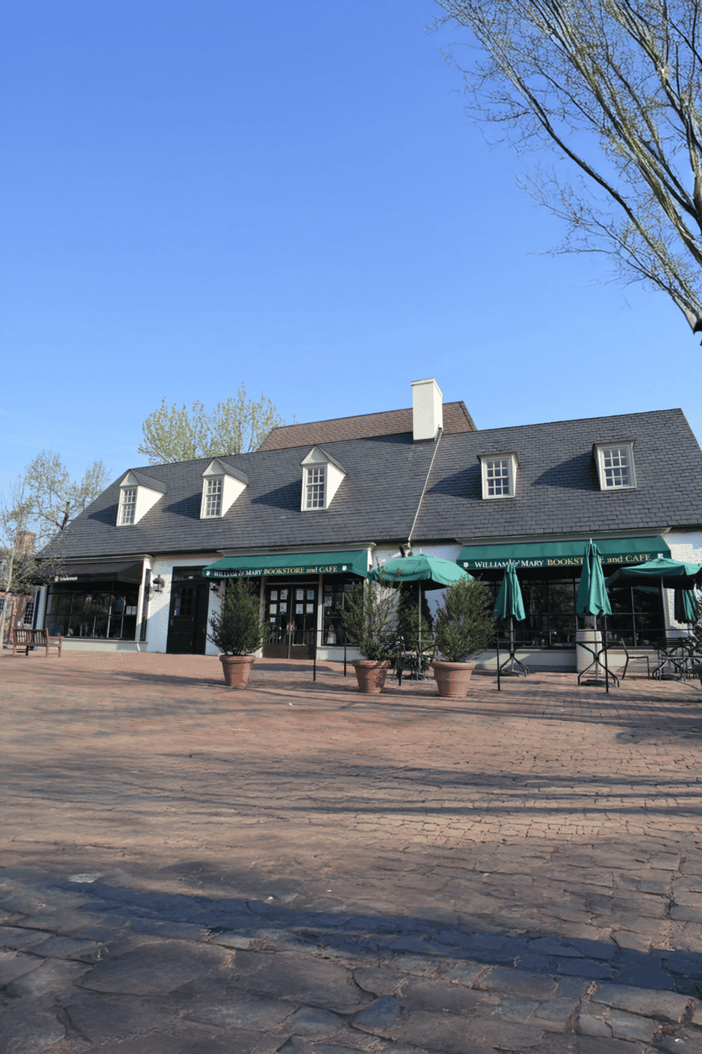 Cozy bookstore and cafe on a brick-paved street with outdoor seating, inviting for book lovers and coffee enthusiasts.