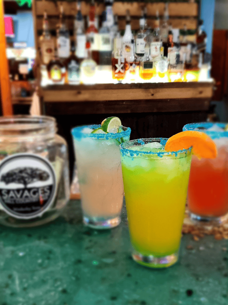 Colorful margaritas with salted rims at a bar, showcasing vibrant cocktails perfect for a lively night out.