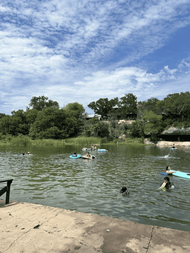 Floating on the river with kayaks and float tubes in a scenic natural setting.