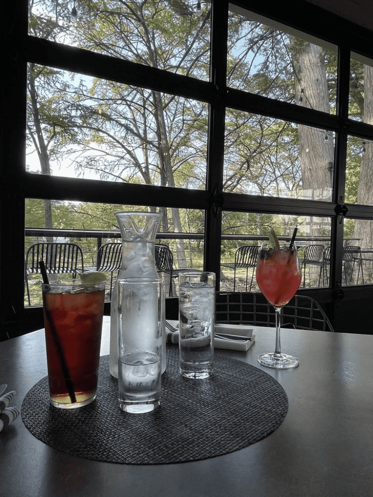 Soothing nature view with colorful cocktails and water glasses at a cozy restaurant.