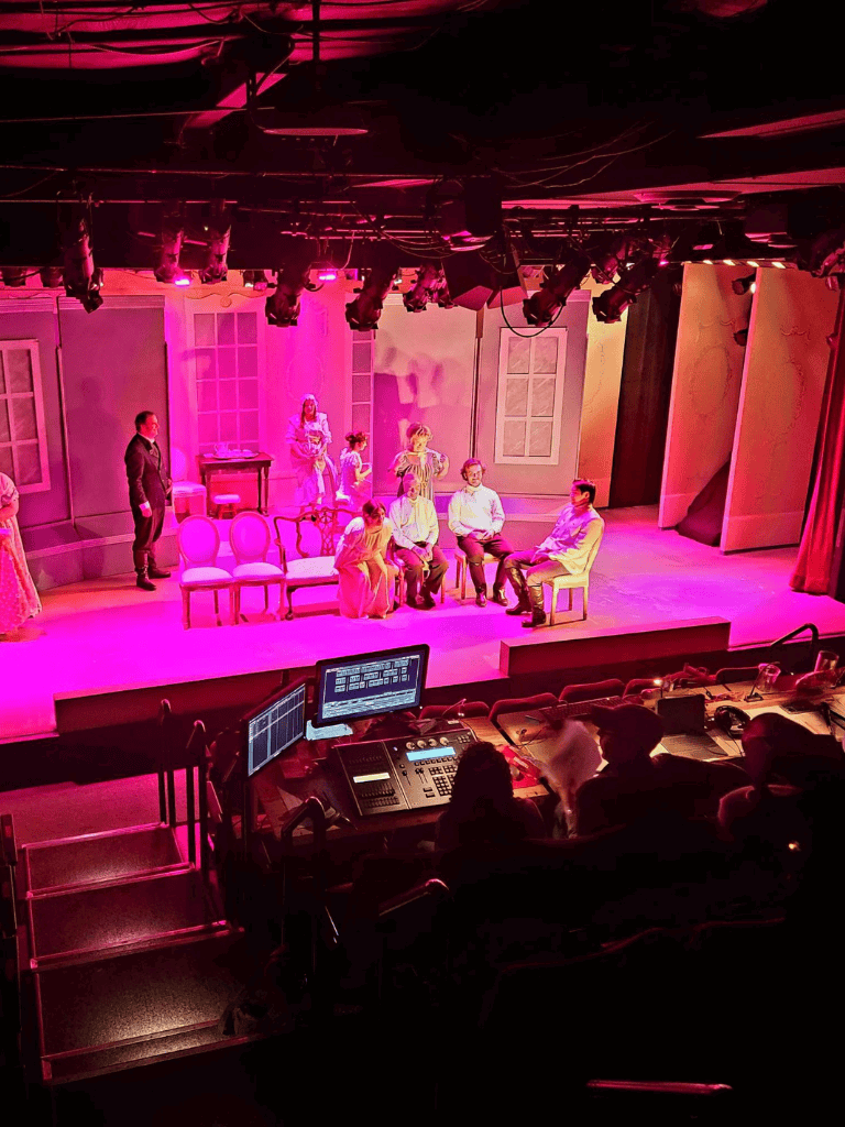 Vibrant stage scene from QuestForDirections theater production, featuring actors and colorful lighting.
