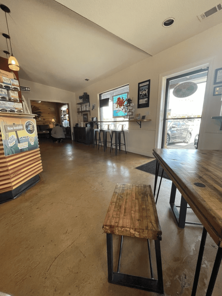 Modern coffee shop interior with wooden tables and bar seating, cozy atmosphere, ideal for casual dining or coffee breaks.